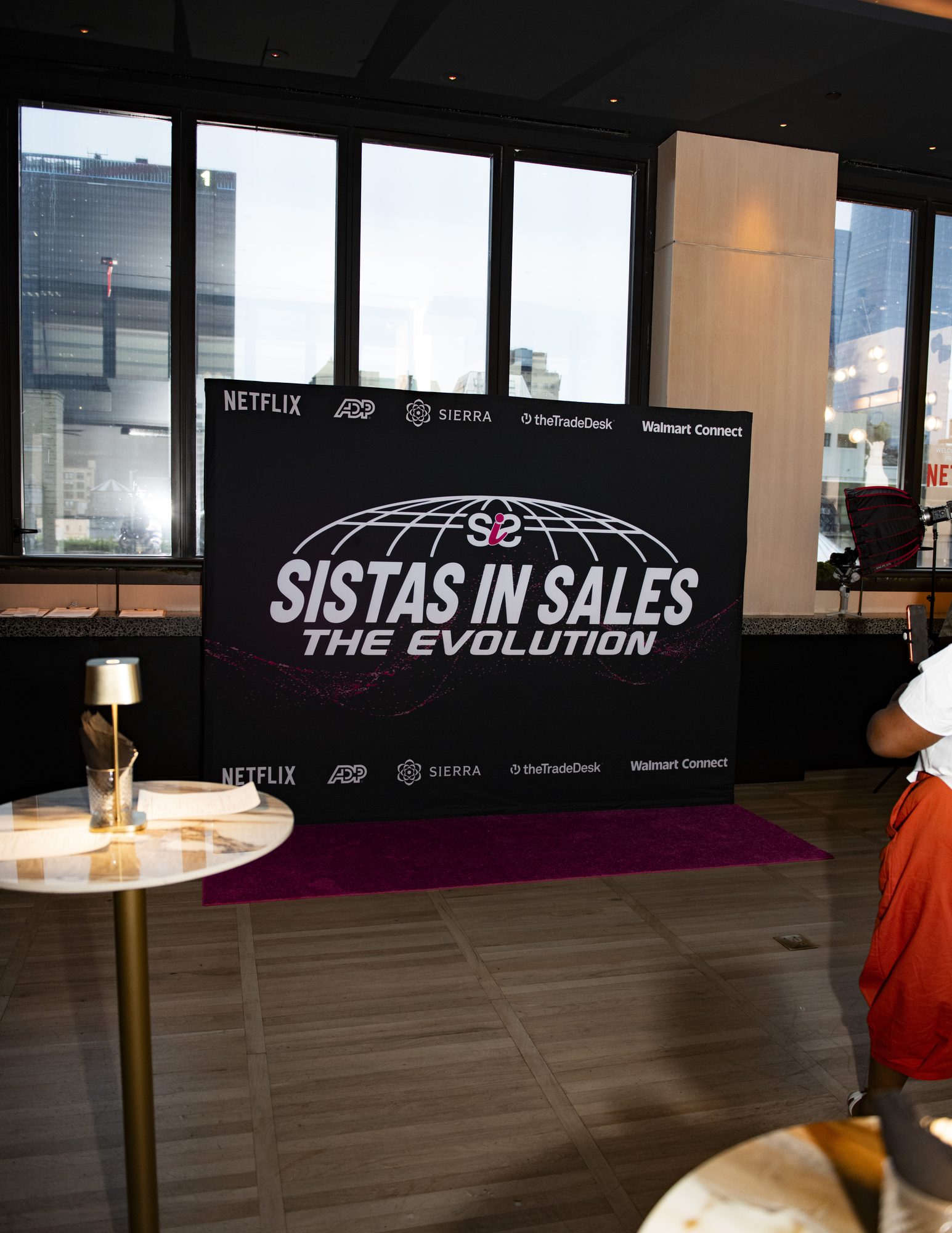 Sistas in Sales: The Evolution step-and-repeat on a pink carpet with partner logos