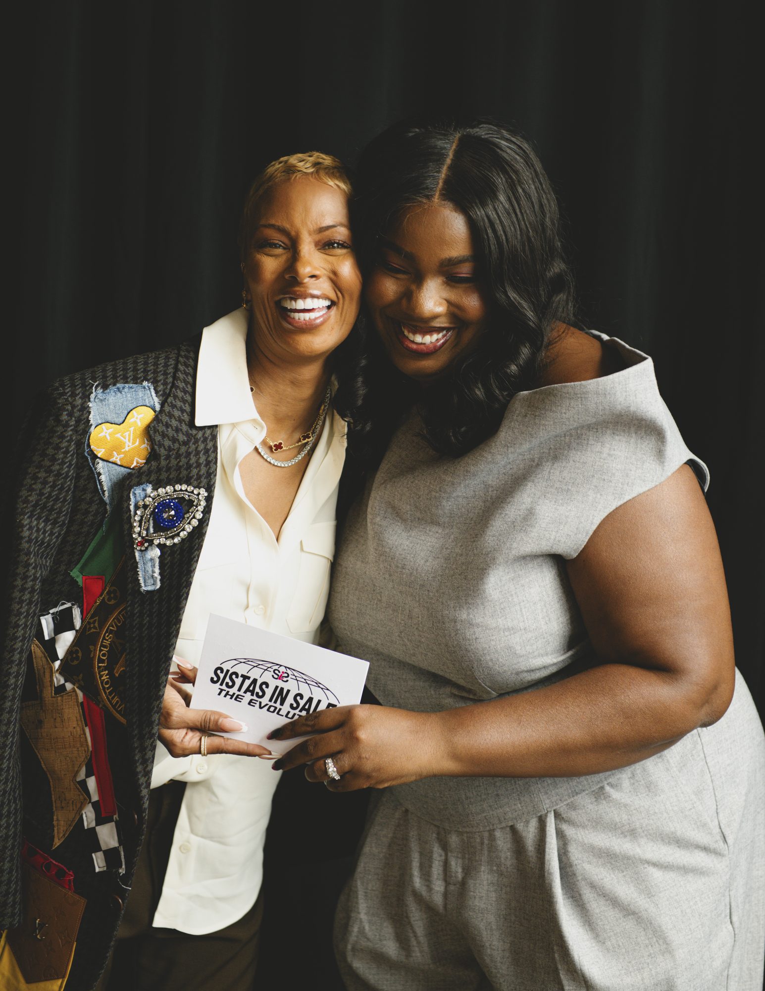 Two women embracing and smiling backstage