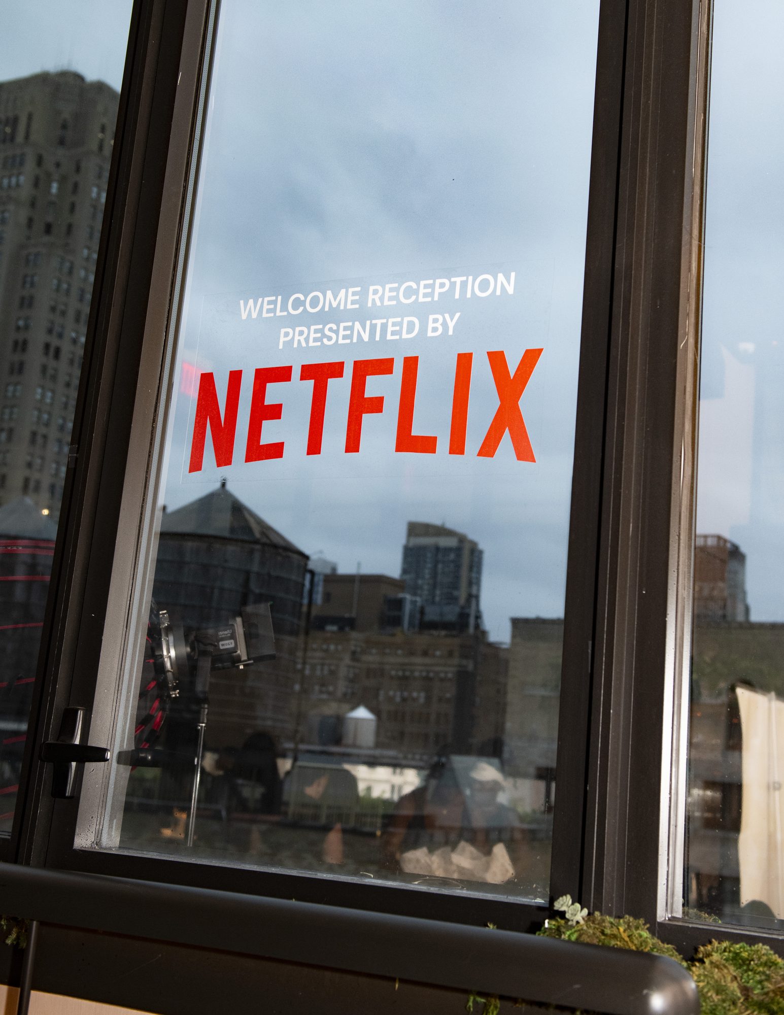 Window reading “Welcome Reception presented by Netflix” overlooking the city skyline