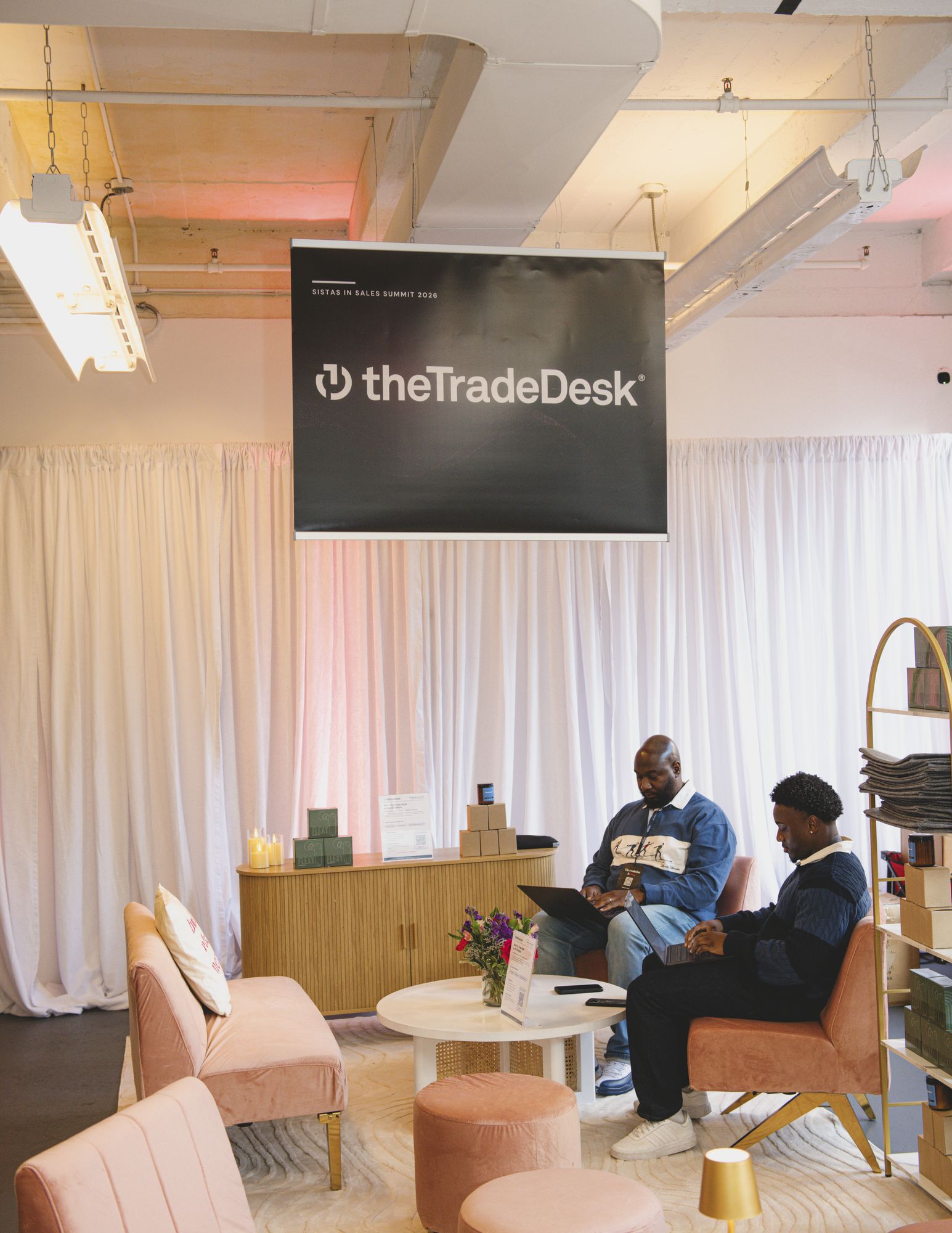 The Trade Desk sign above a lounge with attendees seated