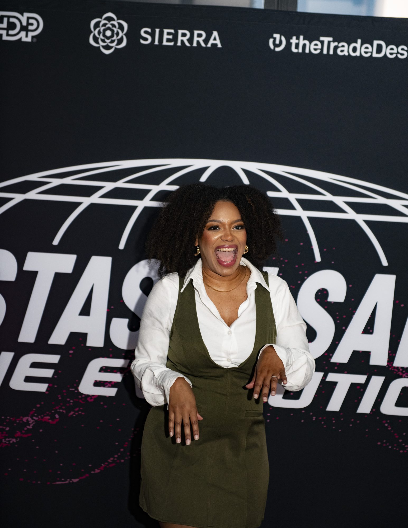 Guest laughing at the Sistas in Sales: The Evolution step-and-repeat