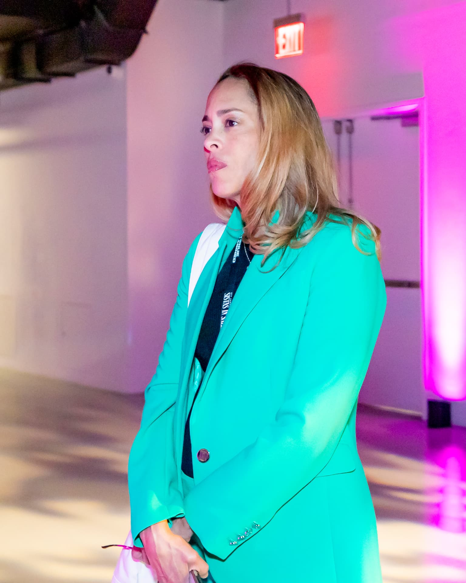SIS attendee in a vibrant teal double-breasted suit at a Sistas in Sales event
