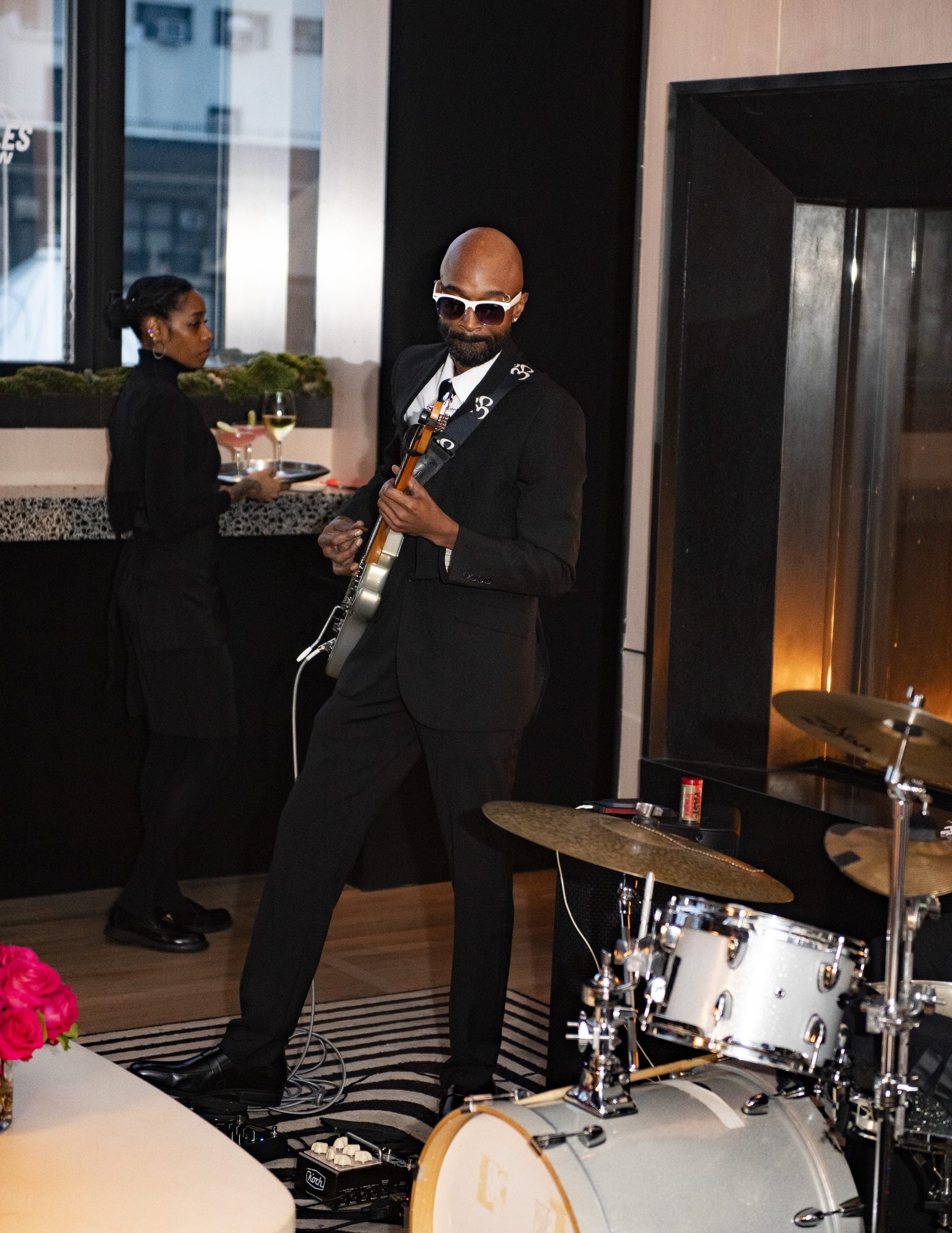 Guitarist in sunglasses performing with the live band